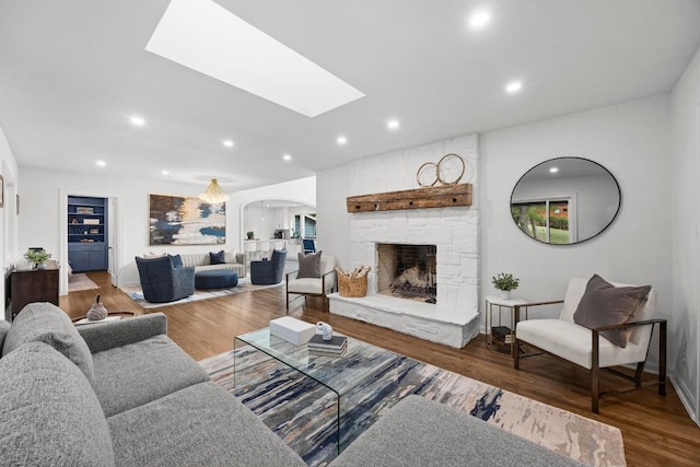 4107 Jefferson St, Austin, TX 78731 - living area featuring arched walkways, recessed lighting, a skylight, wood finished floors, and a stone fireplace