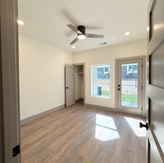 2450 Wickersham Ln Unit 1926, Austin, TX 78741 - unfurnished bedroom with light wood-style floors, access to outside, baseboards, recessed lighting, and ceiling fan