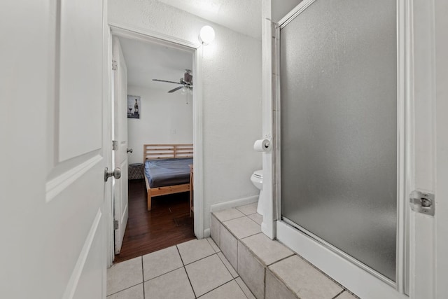 1010 W 23rd St Unit 16, Austin, TX 78705 - ensuite bathroom with a shower stall, toilet, tile patterned flooring, and a ceiling fan
