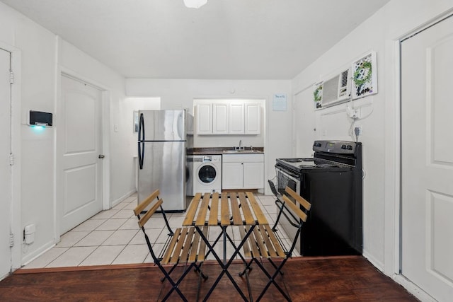 1010 W 23rd St Unit 16, Austin, TX 78705 - kitchen with freestanding refrigerator, black range with electric stovetop, washer / dryer, a sink, and light tile patterned floors