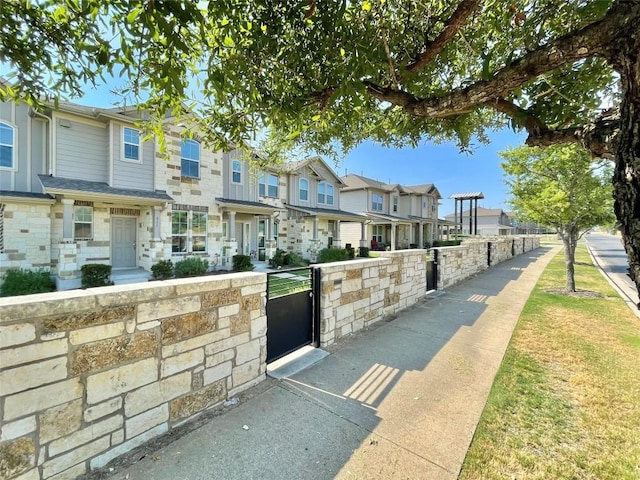513 N Heatherwilde Blvd, Pflugerville, TX 78660 - view of front of property featuring a residential view, stone siding, and a gate