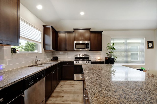 8437 Lamus Wheel, San Antonio, TX 78254 - kitchen featuring appliances with stainless steel finishes, a sink, stone counters, light wood-style floors, and recessed lighting
