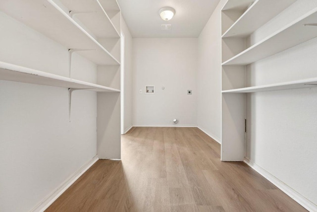 100 Blanco Woods Blvd, Elgin, TX 78621 - laundry area with hookup for an electric dryer, wood finished floors, hookup for a washing machine, and baseboards