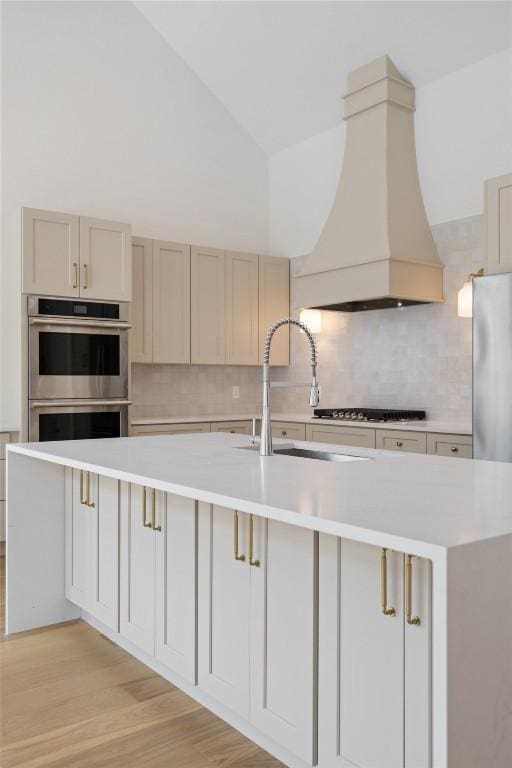 402 Fife Dr, Spicewood, TX 78669 - kitchen featuring custom exhaust hood, stainless steel appliances, light countertops, a sink, and tasteful backsplash