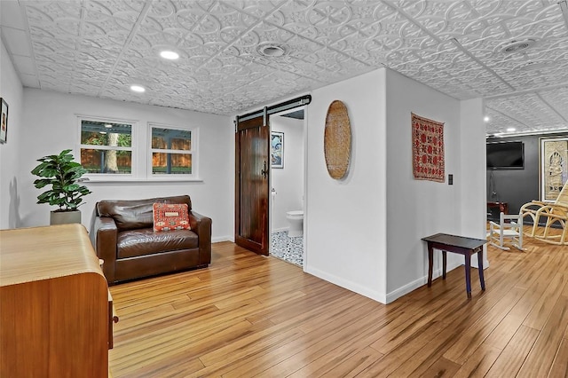 122 W Sierra Cir, San Marcos, TX 78666 - sitting room with an ornate ceiling, a barn door, light wood finished floors, baseboards, and recessed lighting
