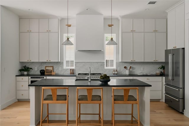 113 Nelray Blvd Unit 1, Austin, TX 78751 - kitchen featuring high quality fridge, dark countertops, decorative backsplash, light wood-style flooring, and recessed lighting