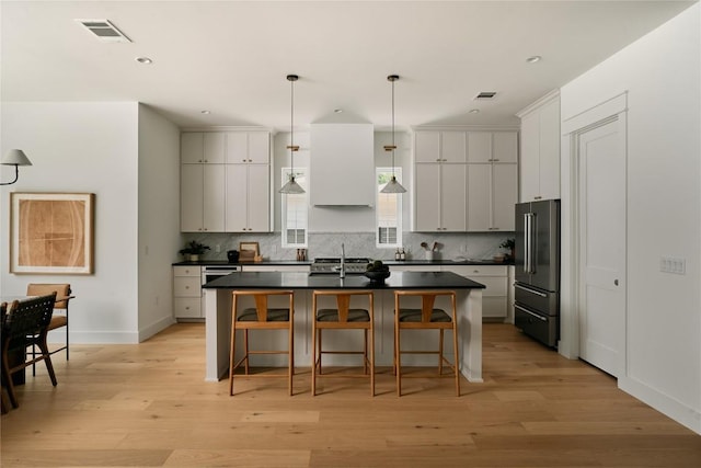 113 Nelray Blvd Unit 1, Austin, TX 78751 - kitchen featuring high quality fridge, dark countertops, a sink, an island with sink, and tasteful backsplash