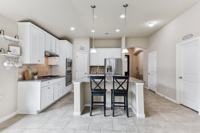 190 Stone View Trl, Austin, TX 78737 - kitchen featuring appliances with stainless steel finishes, under cabinet range hood, arched walkways, decorative backsplash, and recessed lighting