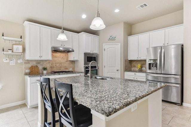 190 Stone View Trl, Austin, TX 78737 - kitchen featuring stainless steel appliances, under cabinet range hood, light tile patterned floors, decorative backsplash, and light stone counters