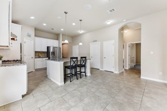 190 Stone View Trl, Austin, TX 78737 - kitchen featuring stainless steel appliances, arched walkways, a center island with sink, recessed lighting, and decorative backsplash