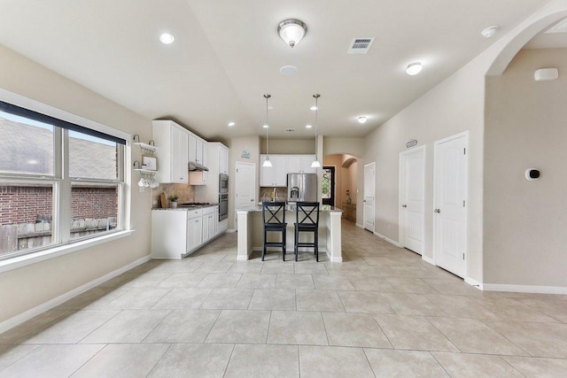 190 Stone View Trl, Austin, TX 78737 - kitchen featuring stainless steel fridge, arched walkways, a breakfast bar, white cabinetry, and recessed lighting