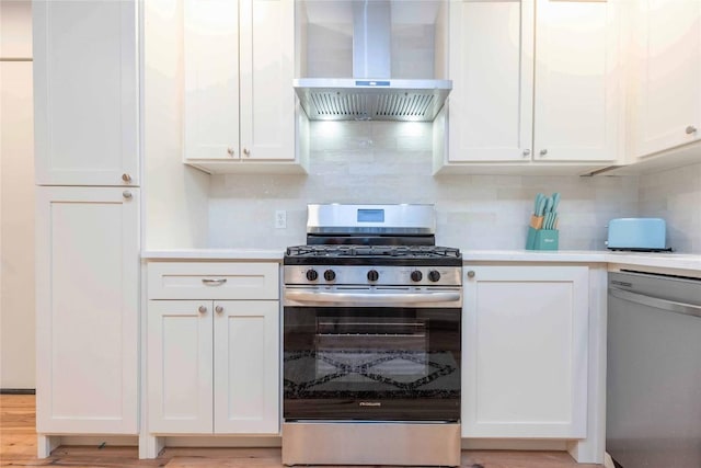 3801 Wilson St, Austin, TX 78704 - kitchen featuring appliances with stainless steel finishes, wall chimney exhaust hood, white cabinets, backsplash, and light countertops