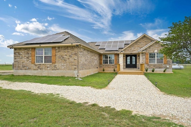 1011 County Road 149, Georgetown, TX 78626 - view of front of property featuring a front yard, roof mounted solar panels, and brick siding