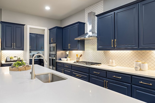 509 Leon Loop, Liberty Hill, TX 78642 - kitchen with wall chimney range hood, stainless steel appliances, a sink, and blue cabinetry