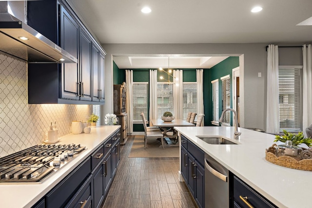 509 Leon Loop, Liberty Hill, TX 78642 - kitchen with a sink, wall chimney range hood, stainless steel appliances, light countertops, and recessed lighting
