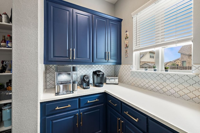 509 Leon Loop, Liberty Hill, TX 78642 - kitchen featuring blue cabinets, backsplash, light countertops, and a textured wall