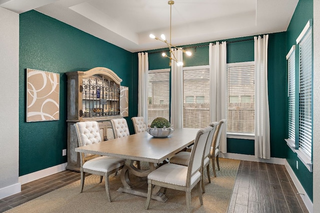 509 Leon Loop, Liberty Hill, TX 78642 - dining room featuring a raised ceiling, dark wood-style flooring, a textured wall, a chandelier, and baseboards