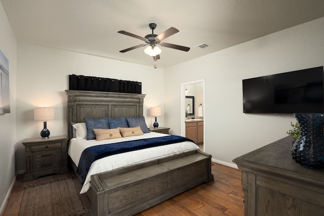 1526 Bonnyview Dr, Canyon Lake, TX 78133 - bedroom featuring wood finished floors, baseboards, connected bathroom, and a ceiling fan