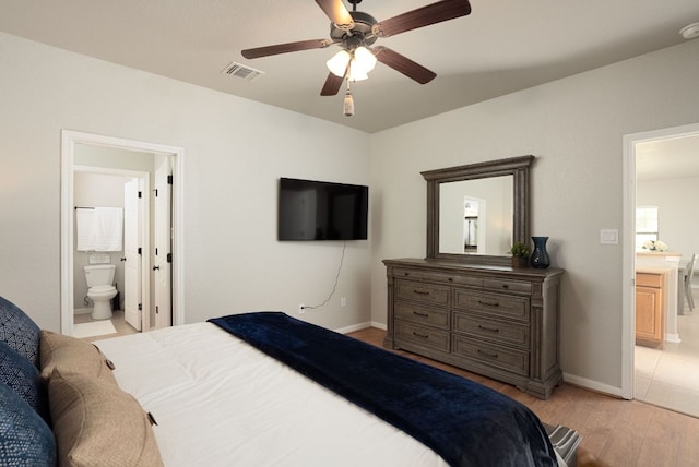 1526 Bonnyview Dr, Canyon Lake, TX 78133 - bedroom with light wood-style floors, ensuite bathroom, baseboards, and a ceiling fan