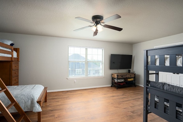 1526 Bonnyview Dr, Canyon Lake, TX 78133 - bedroom featuring wood finished floors, a textured ceiling, baseboards, and ceiling fan