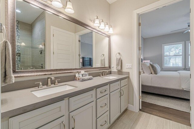 213 Sowing Oak Dr, San Marcos, TX 78666 - full bath featuring double vanity, ensuite bathroom, a stall shower, and wood finished floors