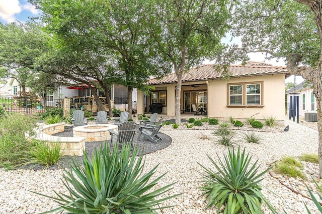 213 Sowing Oak Dr, San Marcos, TX 78666 - back of house with an outdoor fire pit, a ceiling fan, a tile roof, cooling unit, and stucco siding