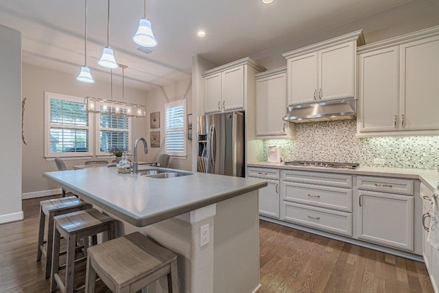 213 Sowing Oak Dr, San Marcos, TX 78666 - kitchen featuring appliances with stainless steel finishes, a sink, under cabinet range hood, dark wood-style flooring, and recessed lighting