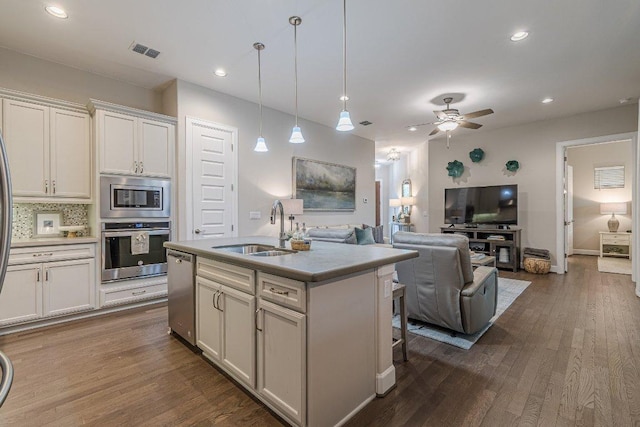 213 Sowing Oak Dr, San Marcos, TX 78666 - kitchen with stainless steel appliances, a sink, open floor plan, dark wood-style floors, and recessed lighting