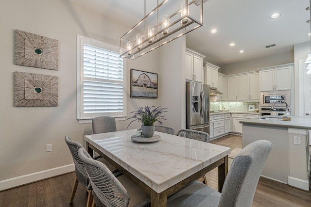 213 Sowing Oak Dr, San Marcos, TX 78666 - dining space with wood finished floors, recessed lighting, baseboards, and a chandelier