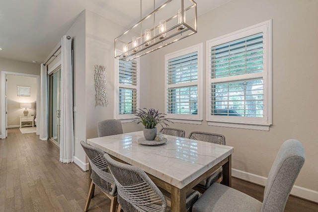 213 Sowing Oak Dr, San Marcos, TX 78666 - dining room featuring baseboards, wood finished floors, and a chandelier