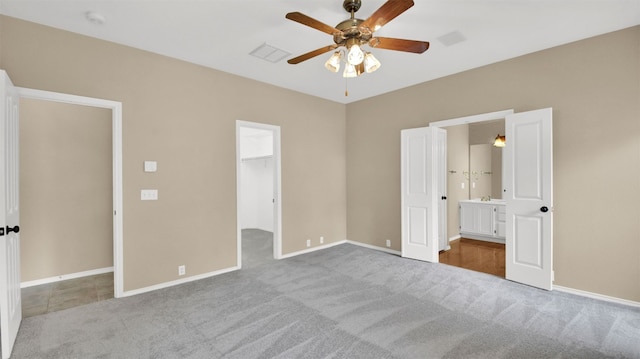 1803 Shooting Star Cv, Cedar Park, TX 78613 - unfurnished bedroom featuring a walk in closet, carpet, ensuite bathroom, ceiling fan, and a closet