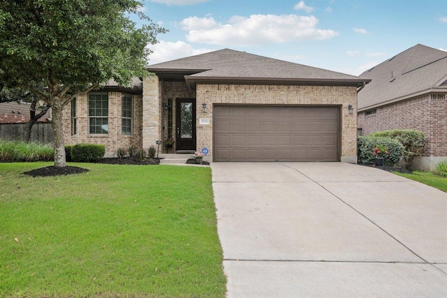 2228 Hilltop Climb Dr, Leander, TX 78641 - view of front of home with driveway, a front yard, a garage, brick siding, and a shingled roof