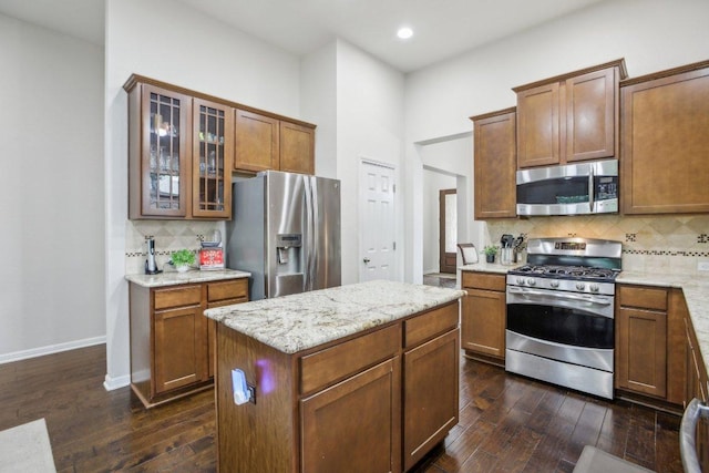 2228 Hilltop Climb Dr, Leander, TX 78641 - kitchen with appliances with stainless steel finishes, dark wood-style flooring, decorative backsplash, glass insert cabinets, and recessed lighting