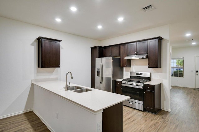 3413 Breckenridge Dr, Austin, TX 78744 - kitchen with stainless steel appliances, a sink, dark brown cabinets, light countertops, and light wood-type flooring