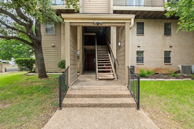 1135 Barton Hills Dr Unit 240, Austin, TX 78704 - doorway to property featuring central air condition unit, a yard, a balcony, and brick siding