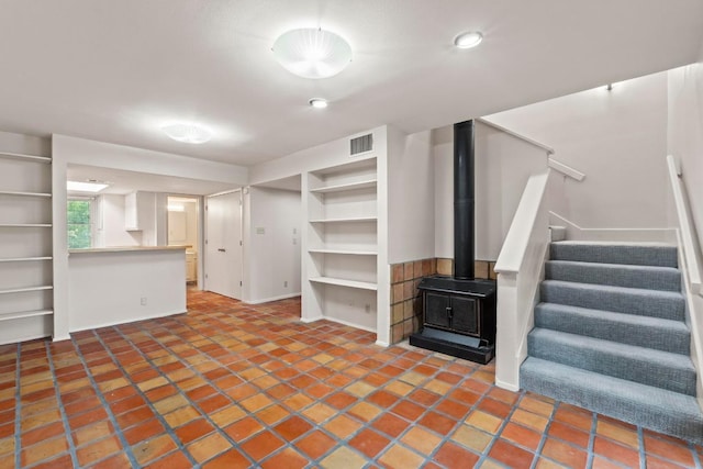 1135 Barton Hills Dr Unit 240, Austin, TX 78704 - below grade area with stairway, a wood stove, built in shelves, and tile patterned flooring