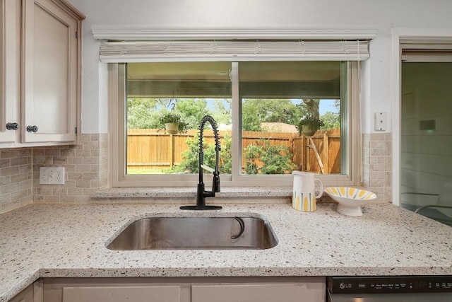 9417 Longvale Dr, Austin, TX 78729 - kitchen view of a sink, backsplash, dishwashing machine, and light stone countertops