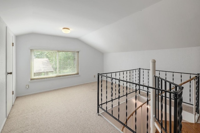 9417 Longvale Dr, Austin, TX 78729 - hallway with an upstairs landing, lofted ceiling, carpet floors, and baseboards