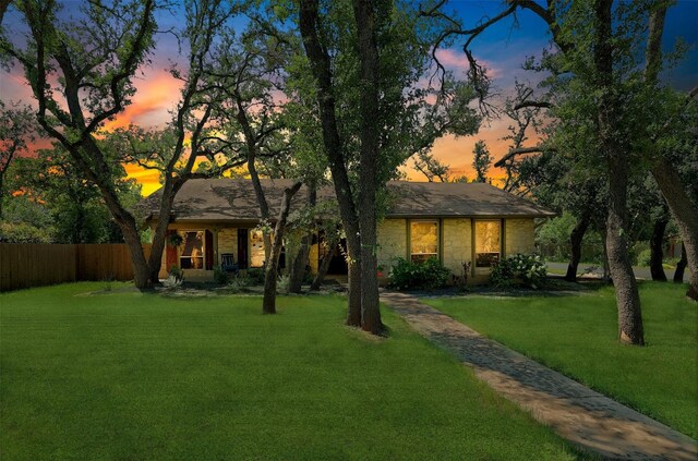 9417 Longvale Dr, Austin, TX 78729 - back of property at dusk featuring stone siding
