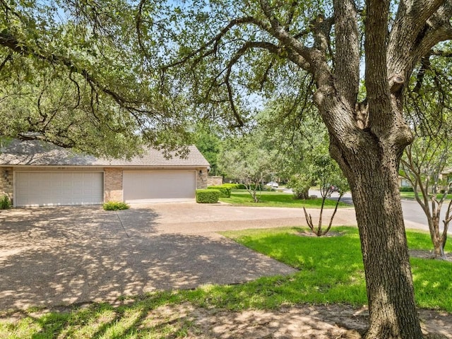 3700 Steck Ave, Austin, TX 78759 - view of front of home featuring brick siding, driveway, a detached garage, and a shingled roof