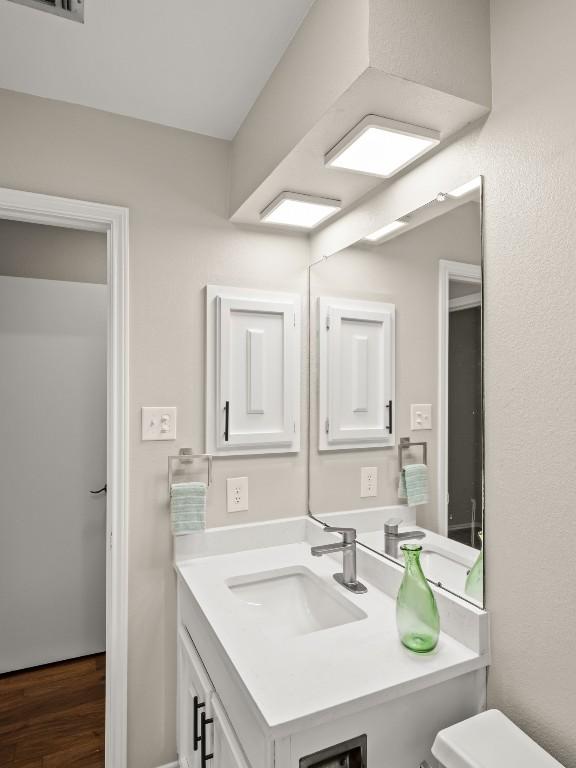 3700 Steck Ave, Austin, TX 78759 - half bath featuring wood finished floors, vanity, and toilet