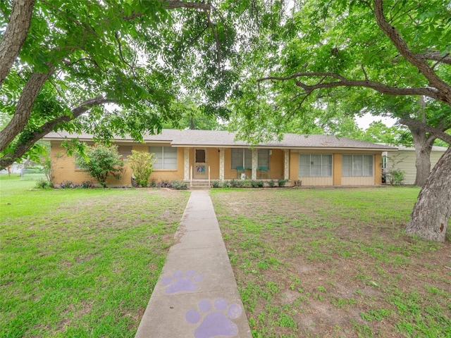 302 Vernon St, Thrall, TX 76578 - ranch-style home with a front yard, brick siding, and covered porch