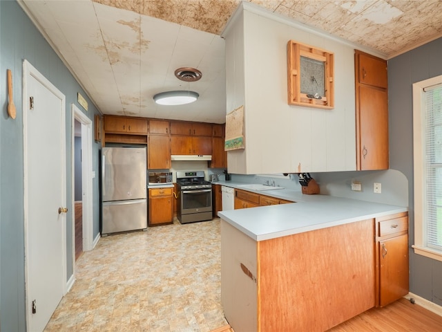 302 Vernon St, Thrall, TX 76578 - kitchen with appliances with stainless steel finishes, a peninsula, brown cabinets, light countertops, and a sink