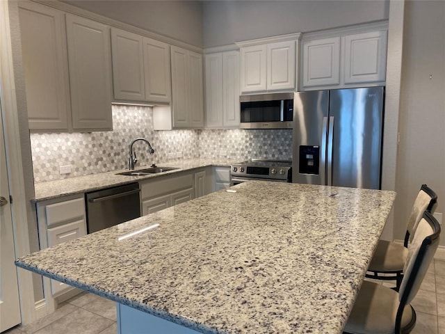 104 Bella Toscana Ave Unit 2106, Austin, TX 78734 - kitchen featuring appliances with stainless steel finishes, light tile patterned flooring, a sink, backsplash, and a breakfast bar