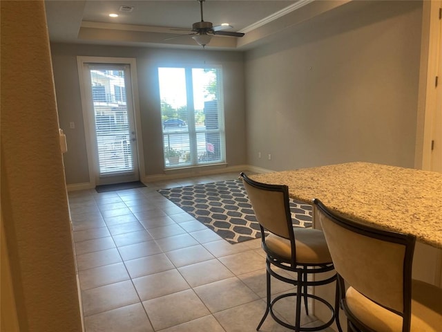 104 Bella Toscana Ave Unit 2106, Austin, TX 78734 - dining area with light tile patterned floors, a ceiling fan, baseboards, a raised ceiling, and ornamental molding