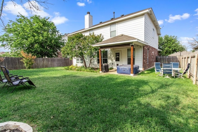 1115 Henderson Dr, Leander, TX 78641 - back of house with a hot tub, brick siding, and a chimney