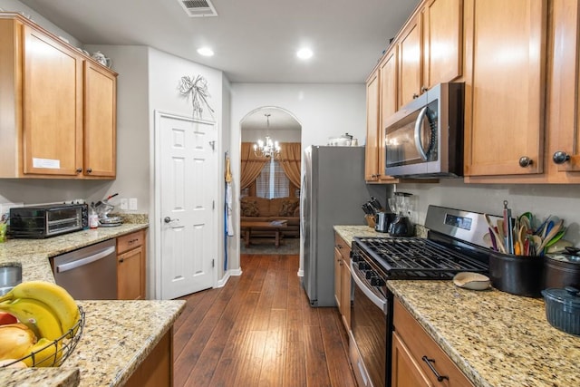 1115 Henderson Dr, Leander, TX 78641 - kitchen with stainless steel appliances, dark wood-style flooring, recessed lighting, light stone counters, and a chandelier