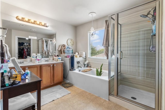 1115 Henderson Dr, Leander, TX 78641 - bathroom featuring a garden tub, double vanity, a shower stall, and a walk in closet