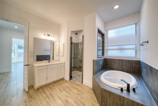 3321 Mongolian Dr, Leander, TX 78641 - bathroom with a garden tub, a stall shower, vanity, wood finished floors, and recessed lighting