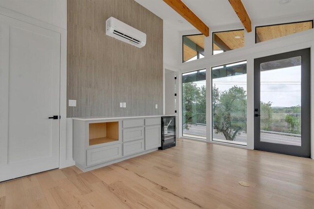 18408 F M Road 1431, Jonestown, TX 78645 - unfurnished living room featuring an AC wall unit, light wood-style floors, healthy amount of natural light, beamed ceiling, and high vaulted ceiling